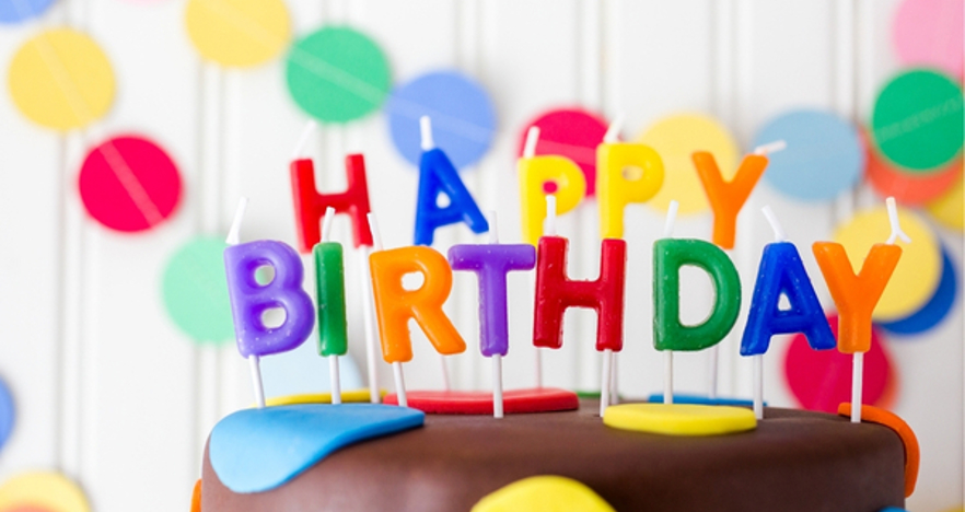 Candles spelling out Happy Birthday on top of cake