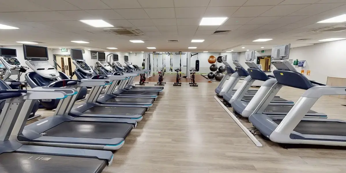 Treadmill machines lined up side by side in the gym